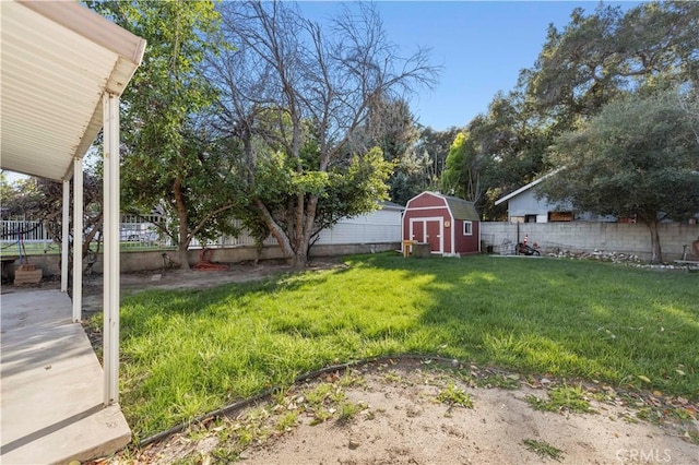 view of yard with a fenced backyard, an outdoor structure, and a shed