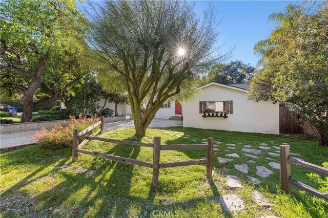 view of front of house featuring stucco siding, a fenced front yard, and a front yard