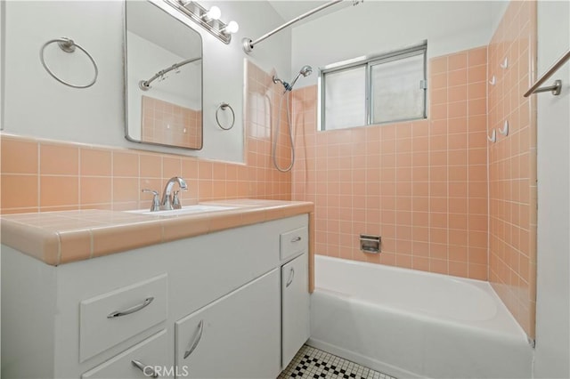 full bath with tile walls, decorative backsplash, tile patterned floors, vanity, and  shower combination