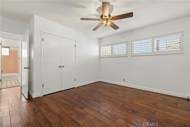 unfurnished bedroom with a closet, ceiling fan, baseboards, and wood finished floors