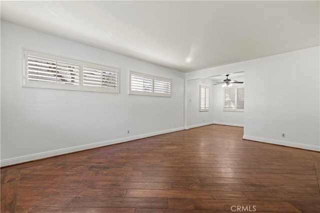 spare room with ceiling fan, baseboards, and wood-type flooring