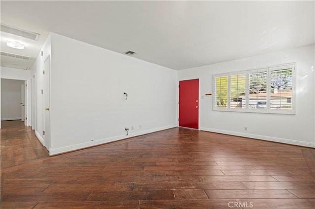 unfurnished living room featuring baseboards, visible vents, and wood-type flooring