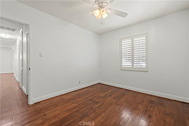 empty room with hardwood / wood-style floors, baseboards, visible vents, and ceiling fan