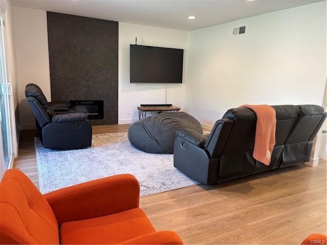 living room with baseboards, recessed lighting, visible vents, and light wood-type flooring