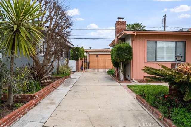 view of property exterior featuring a chimney and a gate