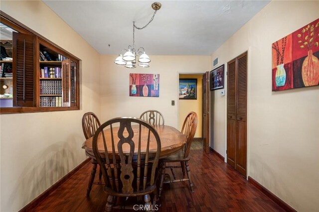 dining space with a chandelier, baseboards, and wood finished floors