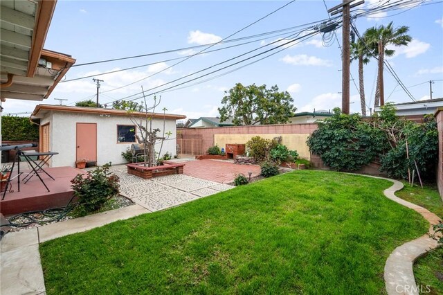 view of yard with a patio, an outdoor structure, and a fenced backyard