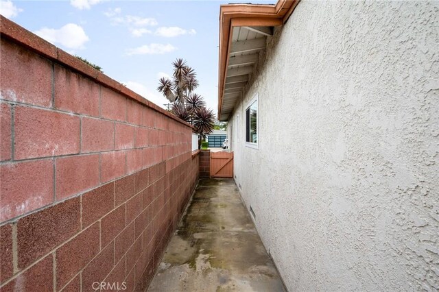 view of side of property with fence and stucco siding