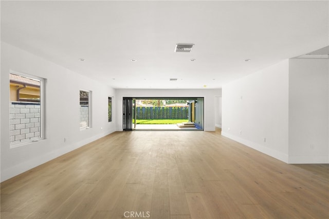 spare room with visible vents, baseboards, and light wood-style floors