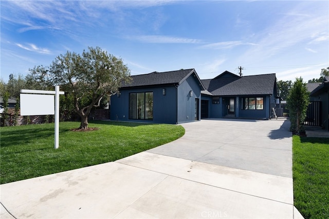 view of front of house with a front lawn, an attached garage, and driveway