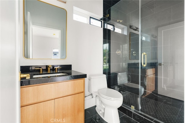 bathroom featuring a stall shower, toilet, and vanity