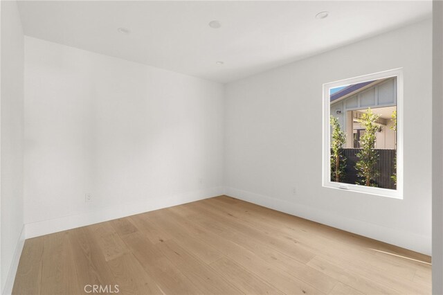 empty room with baseboards and light wood-style flooring