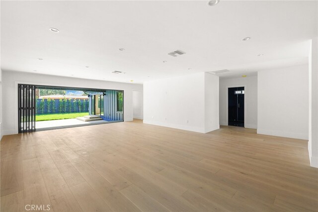 spare room with recessed lighting, light wood-type flooring, baseboards, and visible vents