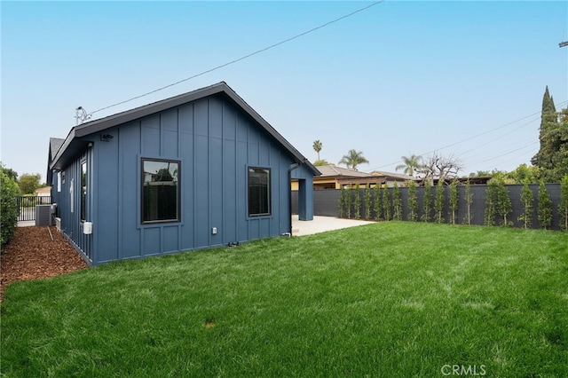 rear view of property with central AC unit, a yard, a fenced backyard, a patio area, and board and batten siding