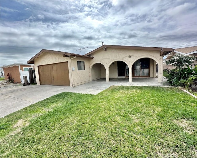 view of front of house with stucco siding, a front lawn, a patio, concrete driveway, and a garage