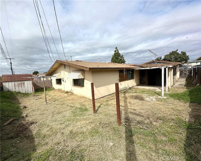 rear view of house with stucco siding