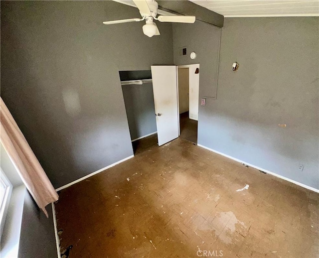 unfurnished bedroom with lofted ceiling, a ceiling fan, baseboards, and a closet