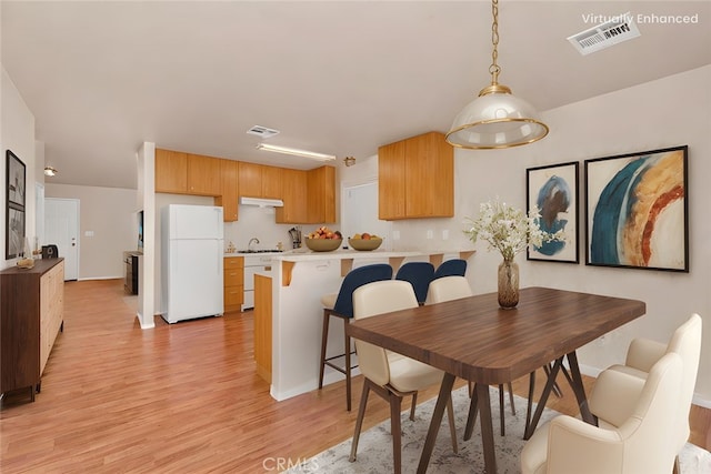 dining space with visible vents and light wood-type flooring