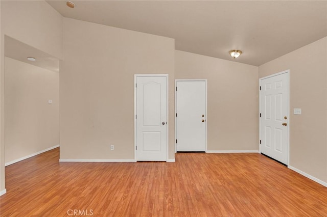 empty room with baseboards and light wood-type flooring