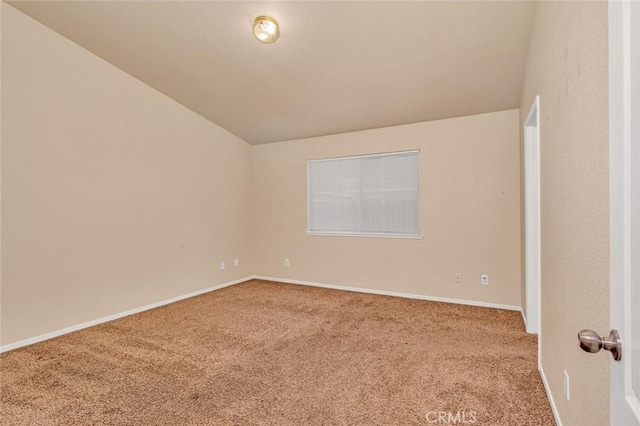 empty room with baseboards, carpet floors, and lofted ceiling