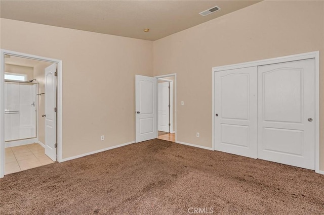 unfurnished bedroom with visible vents, ensuite bathroom, a closet, carpet floors, and baseboards