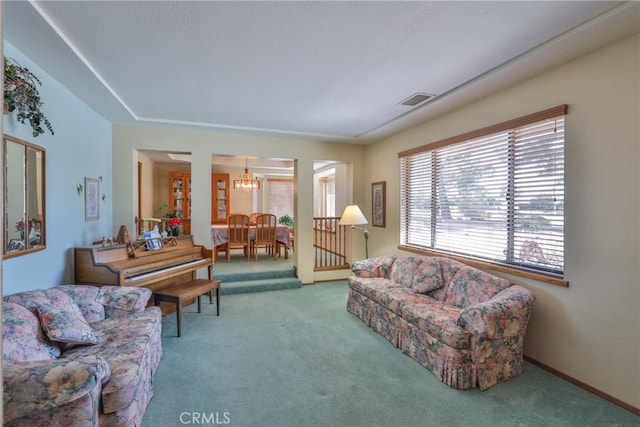 carpeted living room with visible vents, baseboards, and an inviting chandelier