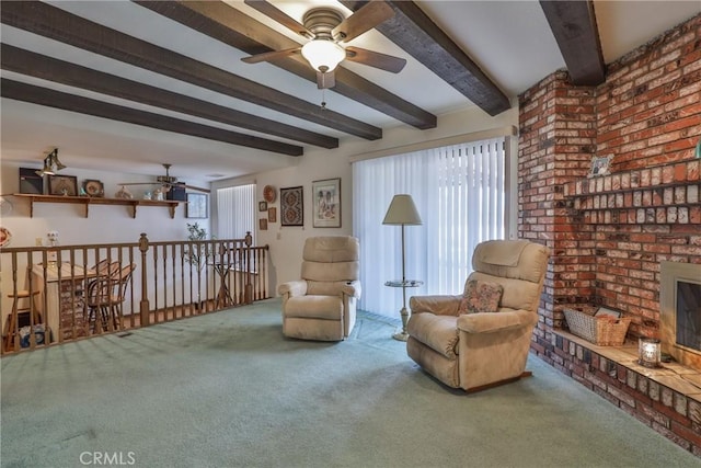 living area with a ceiling fan, carpet, beam ceiling, a brick fireplace, and an upstairs landing