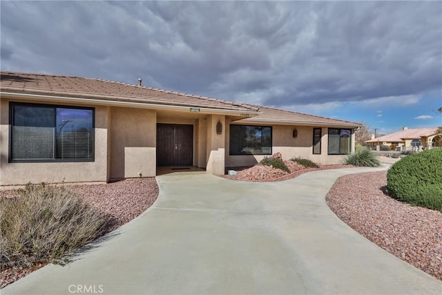 view of front of property featuring stucco siding, a garage, and driveway