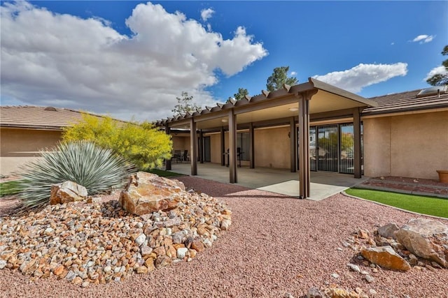 back of property with a patio area and stucco siding