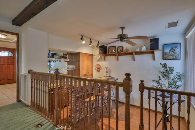 interior space with visible vents, track lighting, baseboards, beam ceiling, and a ceiling fan