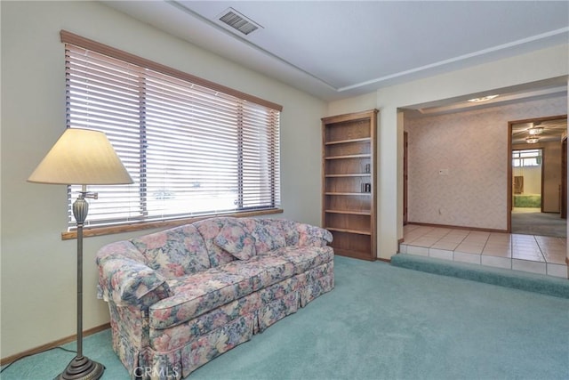 living area with carpet, visible vents, and baseboards