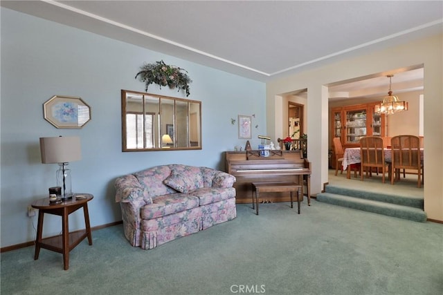 living area featuring baseboards, an inviting chandelier, and carpet floors