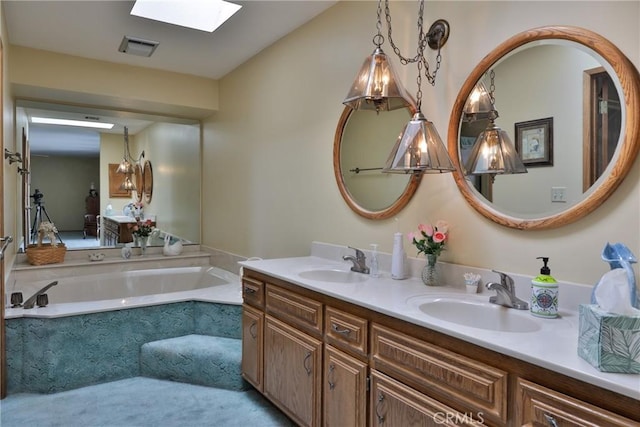 full bathroom featuring double vanity, visible vents, a skylight, and a sink