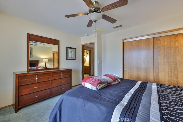 bedroom featuring visible vents, a ceiling fan, a closet, carpet flooring, and baseboards