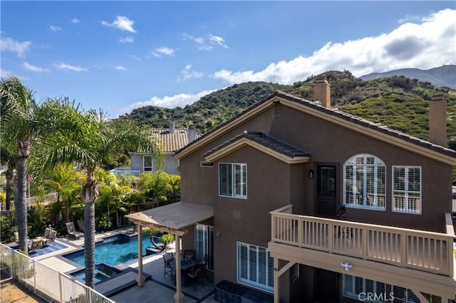 1412 San Clemente Cir, Corona, CA 92882 - rear view of property featuring stucco siding, a fenced in pool, a mountain view, a chimney, and a patio area