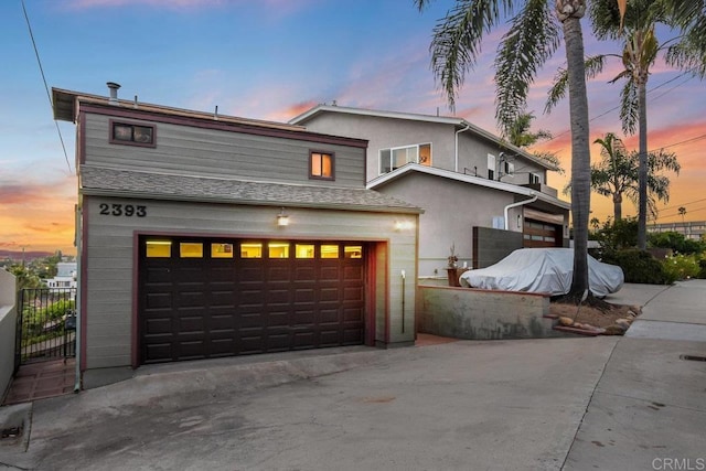 view of front of house featuring stucco siding, driveway, and a garage