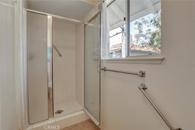 full bathroom featuring a shower stall and tile patterned flooring