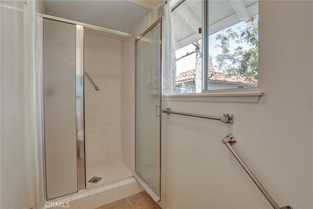 full bathroom with tile patterned flooring and a shower stall