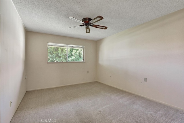 spare room with a textured ceiling, a ceiling fan, and light carpet
