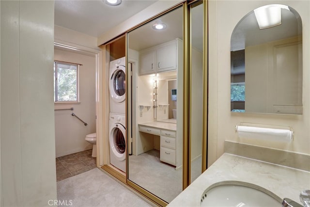full bathroom featuring recessed lighting, stacked washer and dryer, toilet, and vanity