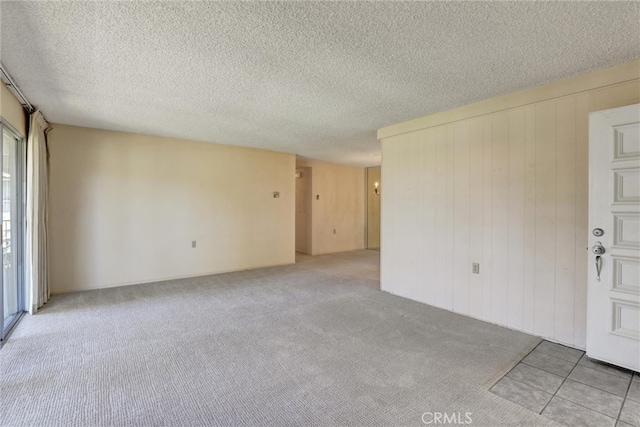 unfurnished room with carpet floors and a textured ceiling