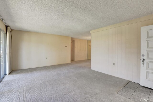 carpeted empty room featuring a textured ceiling