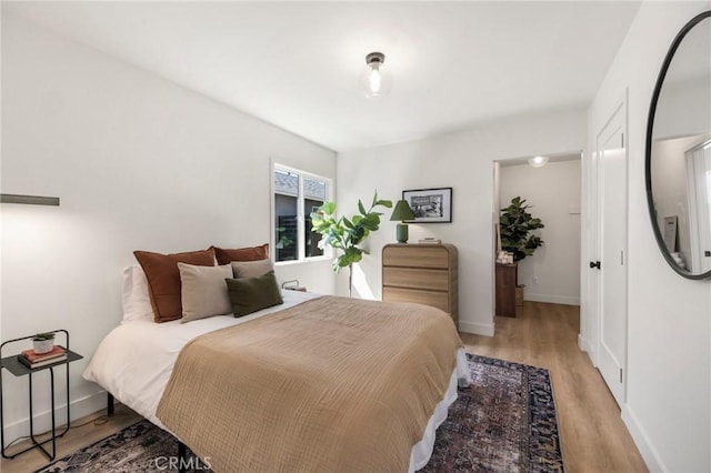 bedroom featuring baseboards and light wood finished floors