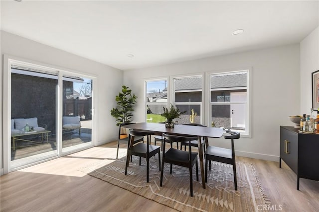 dining space with baseboards and light wood finished floors