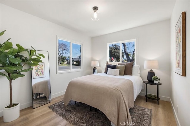 bedroom with light wood-type flooring and baseboards