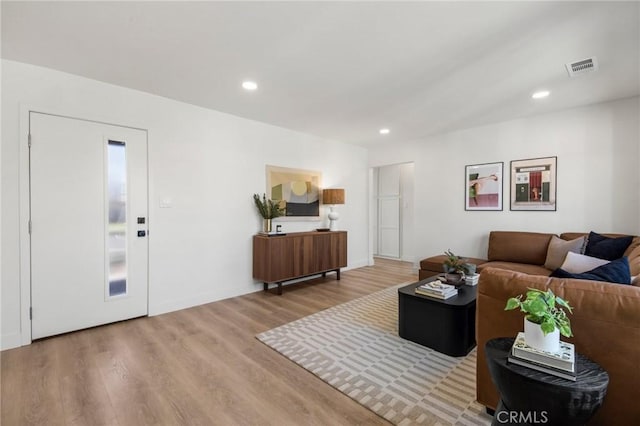 living area with visible vents, wood finished floors, recessed lighting, elevator, and baseboards