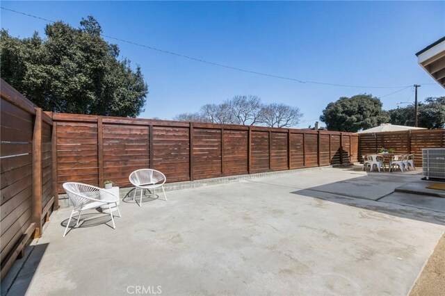 view of patio featuring cooling unit and a fenced backyard