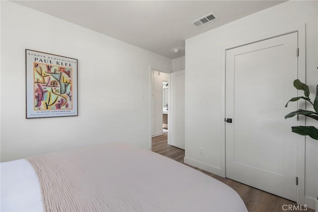 bedroom with visible vents and wood finished floors