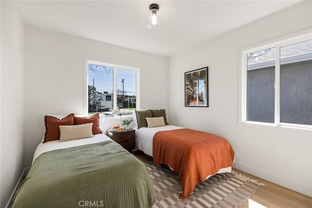 bedroom with baseboards and wood finished floors