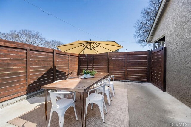 view of patio with outdoor dining space and a fenced backyard